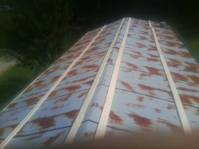 Rusted metal roof panels with new wood purlins before replacement — Storm Damage Roof Repair in Princess Anne by Roofing Brothers