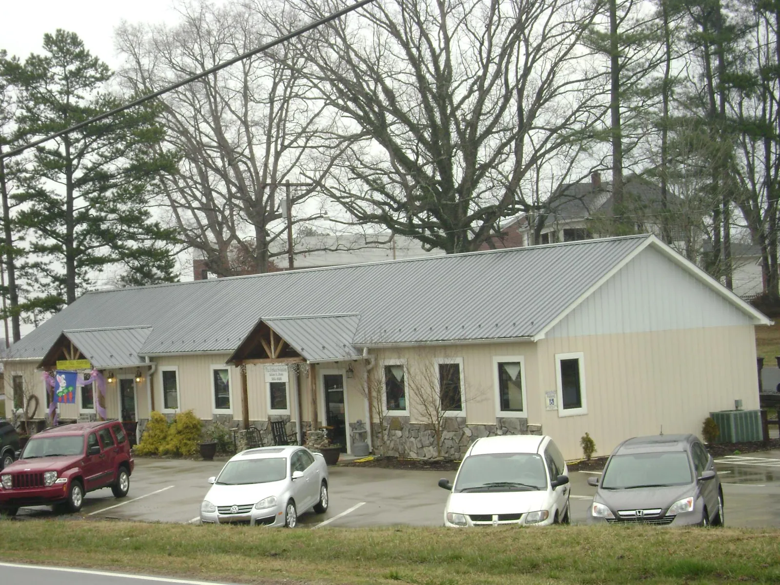 Gray metal roof with timber entry brackets on a small commercial building in Princess Anne