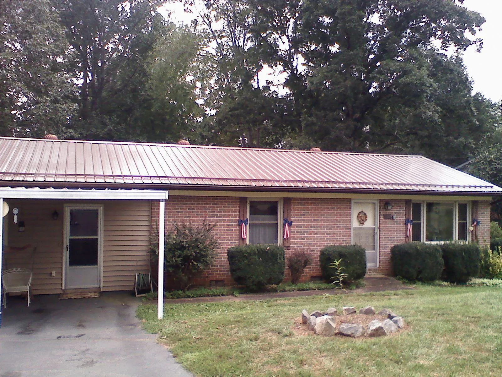 Bronze metal roof and carport on a brick ranch home — Roof Repair work by our crew in Princess Anne